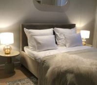 King size bed with feather pillows and duvet, satin linens
