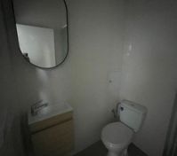 Toilet, sink, mirror and shower corner 