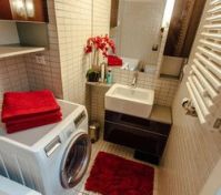 Bathroom with washing machine, bath & shower head.