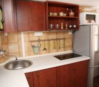 A simple kitchen with everything you need for making food at home, including a fridge and a freezer.